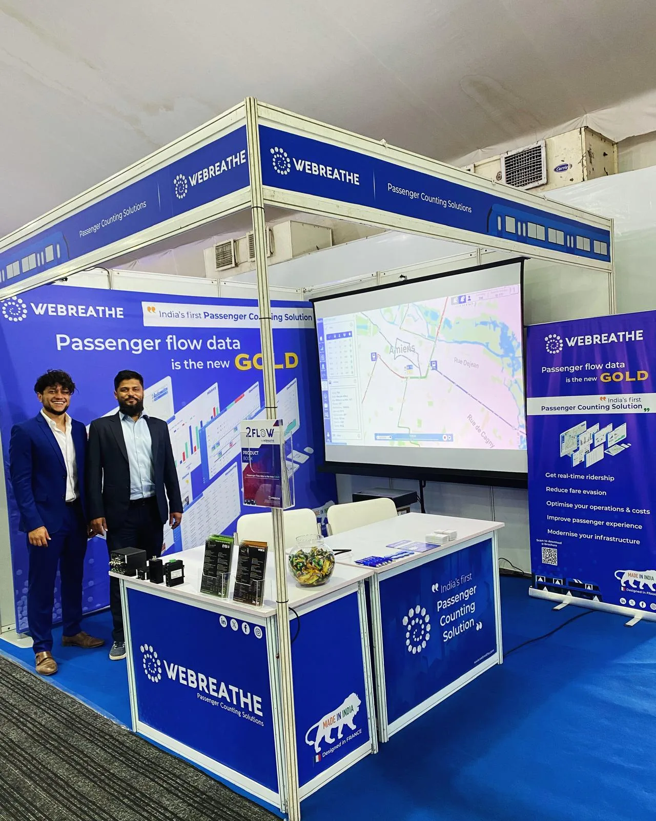 Wide view of the WEBREATHE booth, team, display, and hardware